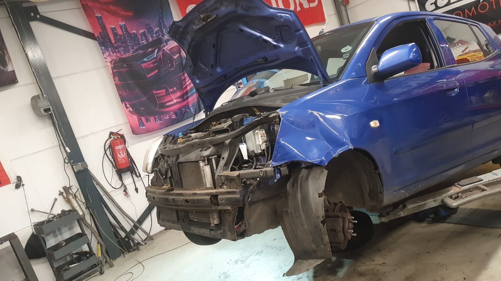 Blauwe auto op de brug met de voorkant gedemonteerd