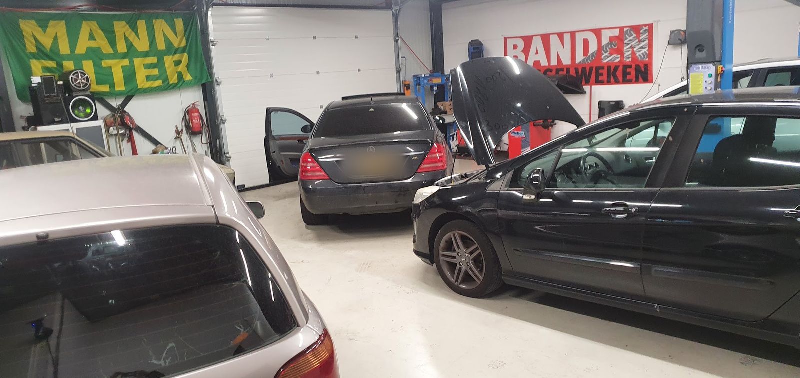 De werkplaats met auto's en het spandoek voor banden wisselen
